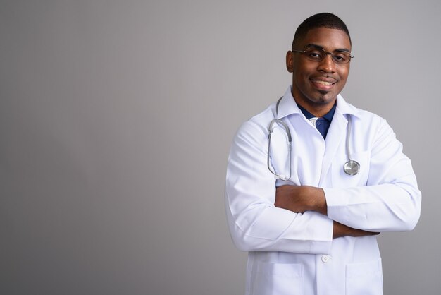 Médico joven guapo africano en gris