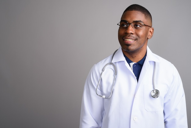 Médico joven guapo africano en gris