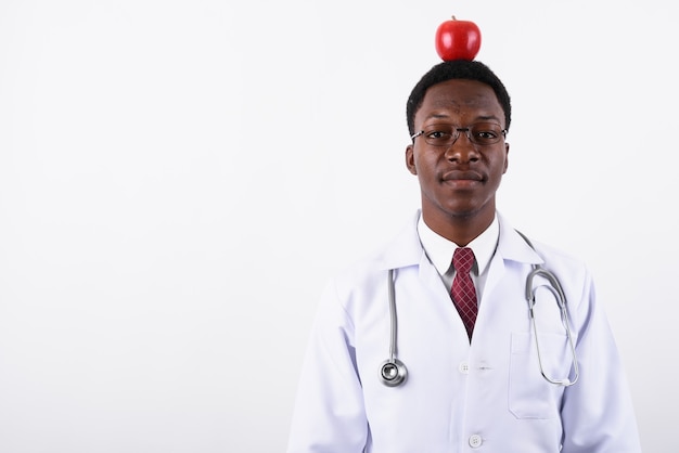 Médico joven guapo con anteojos contra un blanco