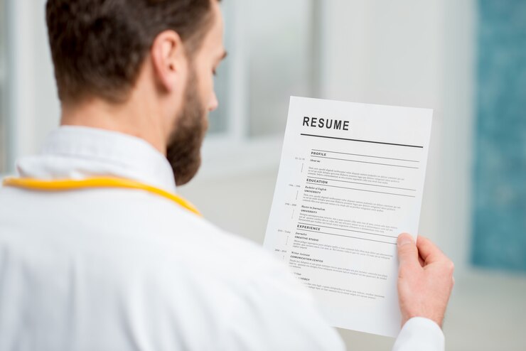 Foto médico lendo currículo para contratação de emprego no hospital