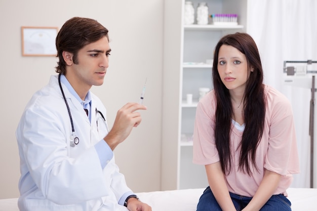 Médico macho preparando injeção para paciente