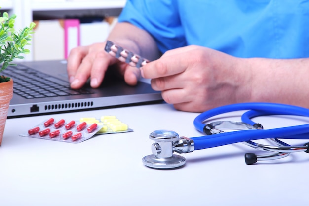 Médico mão mostrando caixas de drogas no Office Desktop. Cuidados de saúde, médicos e conceito de farmácia.