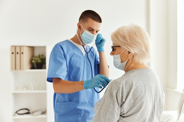 Médico con máscara médica examina a un paciente de atención médica Foto de alta calidad