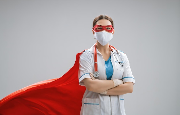 Foto médico con mascarilla y capa de superhéroe durante el brote de coronavirus virus