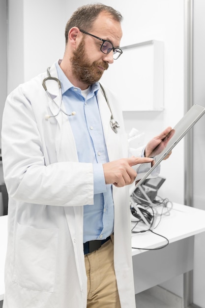 Médico masculino con bata blanca y estetoscopio usando conexión de red de tableta en la habitación del hospital Concepto de red de tecnología médica