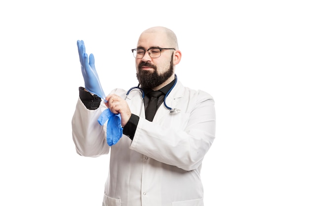 Foto médico masculino com um jaleco branco veste luvas descartáveis azuis. agenda cheia durante a pandemia de coronavírus.