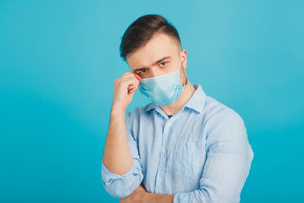 Médico masculino em máscara médica em fundo azul