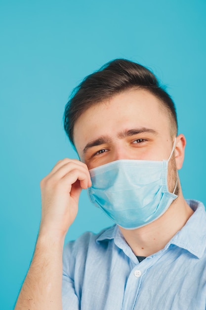 médico masculino em máscara médica em fundo azul