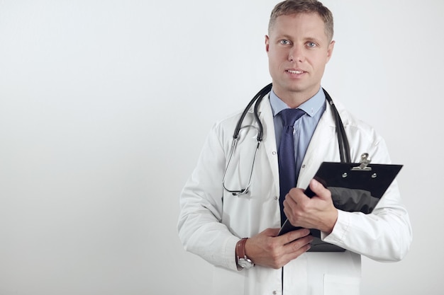 Médico masculino em pé com pasta isolada no fundo branco