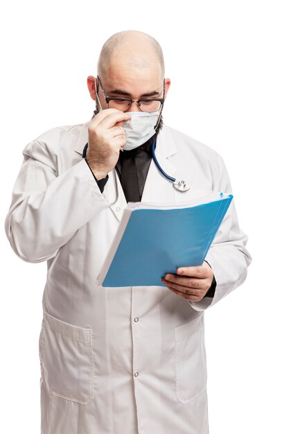 médico masculino em uma máscara Olha para os documentos. agenda cheia durante a pandemia de coronavírus.