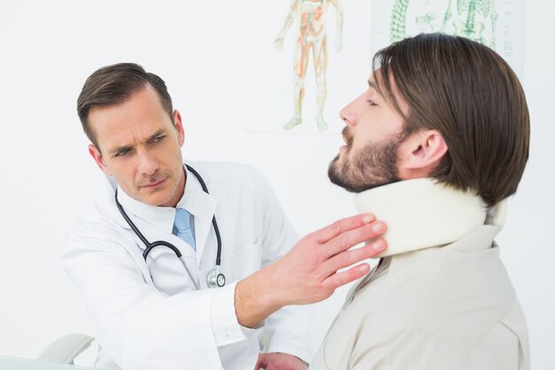 Foto médico masculino examinando um pescoço de pacientes