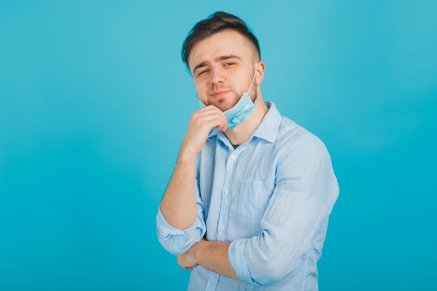 médico masculino en máscara médica sobre fondo azul