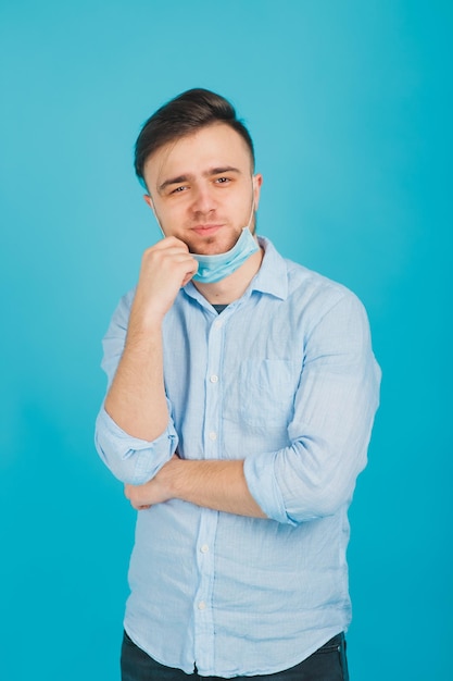 médico masculino en máscara médica sobre fondo azul