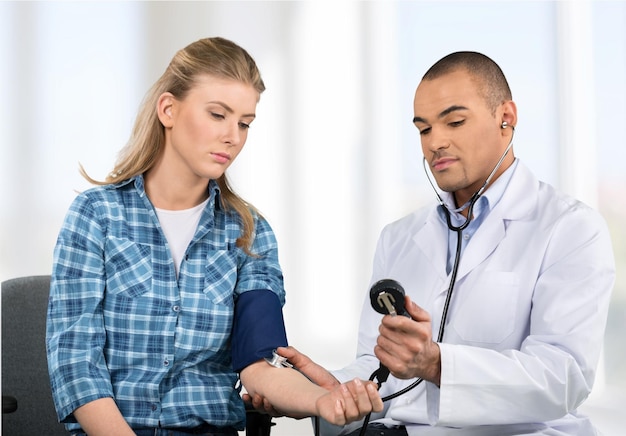 Foto médico masculino mede a pressão para paciente do sexo feminino na clínica