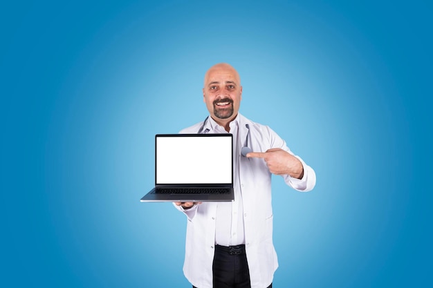 Médico masculino segurando laptop moderno apontando a tela em branco vazia do notebook simulado