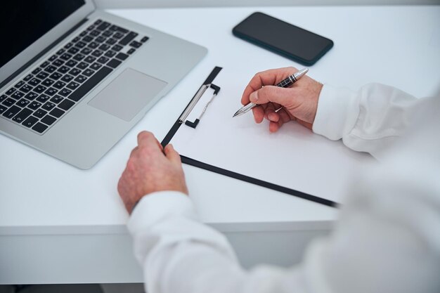 Médico masculino usando notebook no escritório moderno