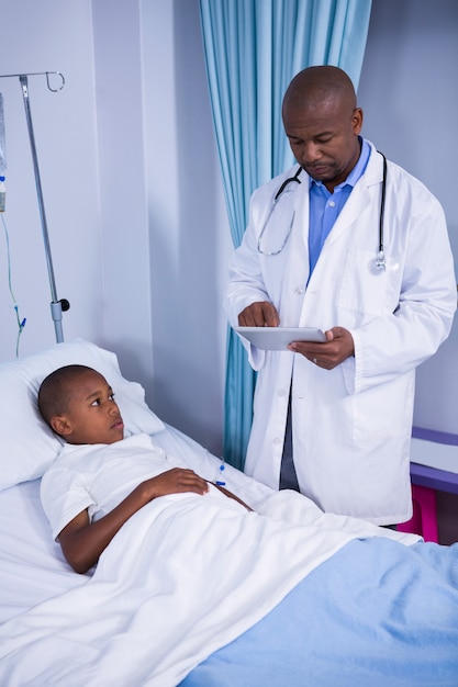 Médico masculino usando tablet digital durante a visita na enfermaria