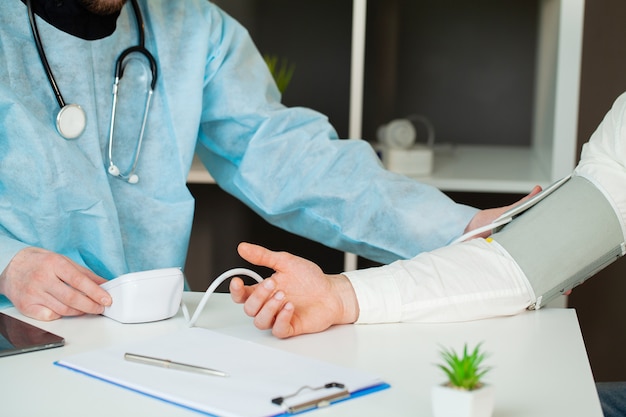 Médico mede a pressão do paciente na clínica