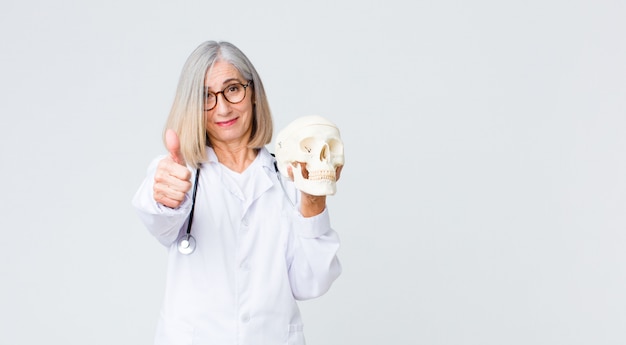 Médico de mediana edad mujer sosteniendo una calavera