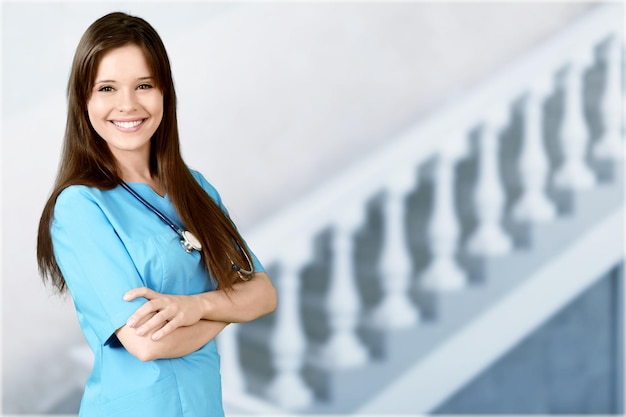 Médico médico mujer sobre fondo azul de la clínica.