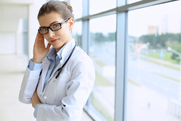 Médico médico mujer sobre fondo azul clínica