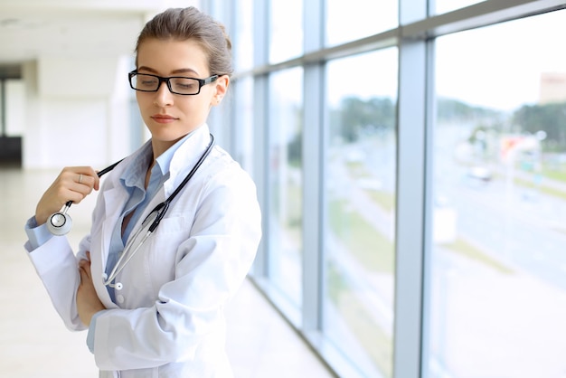 Médico médico mujer sobre fondo azul clínica