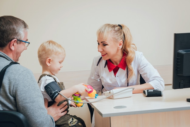 Médico medir la presión sanguínea de un niño.