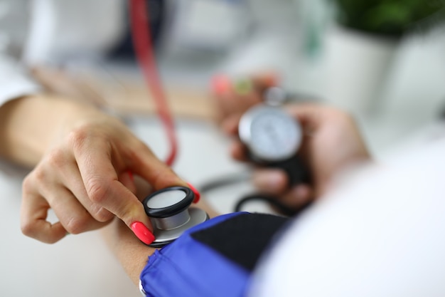 Foto el médico mide la presión arterial del paciente en la cita