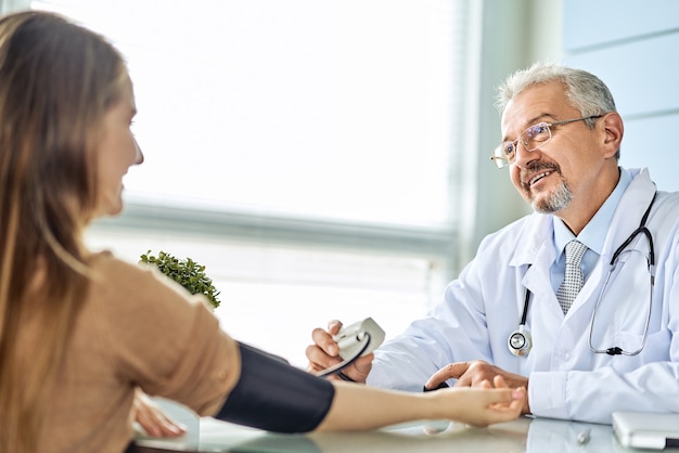 El médico mide la presión del paciente.