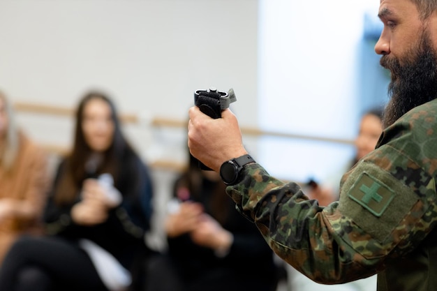 Un médico militar barbudo de un año muestra a un civil un torniquete para detener el sangrado durante los primeros auxilios.