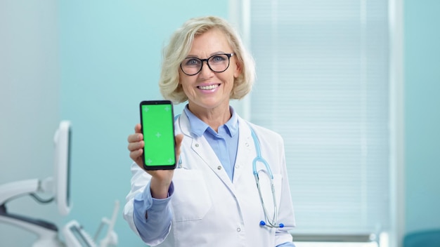 Médico mostra resultados da análise segurando o telefone na mão