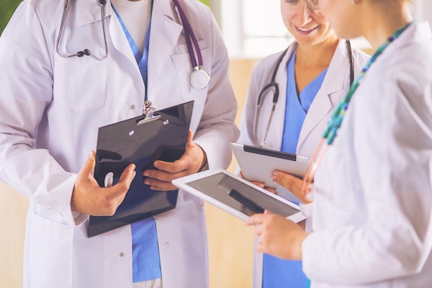 Médico mostrando algo em seu tablet para sua equipe médica