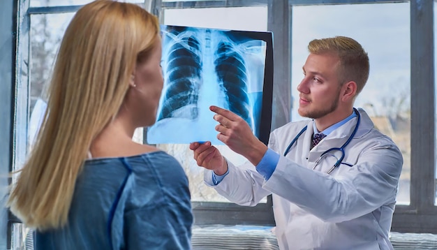 Foto el médico muestra a su paciente una radiografía de sus pulmones.