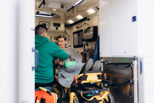 Foto un médico con una mujer dentro de una ambulancia