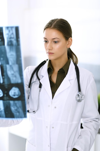 Médico mujer examinando la imagen de rayos X en el hospital Cirujano u ortopedista en el trabajo en la clínica Concepto de medicina y atención médica
