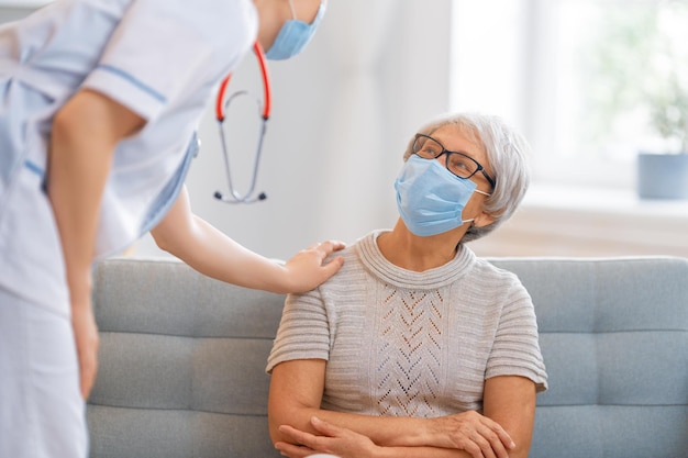 Médico y mujer mayor con máscaras faciales