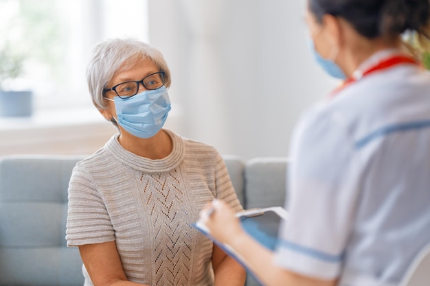 Médico y mujer mayor con máscaras faciales