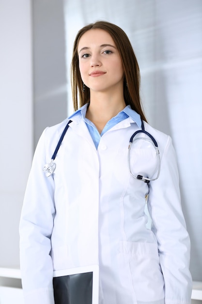 Foto médico mulher feliz e alegre enquanto está no escritório do hospital em destaque o conceito de medicina e saúde