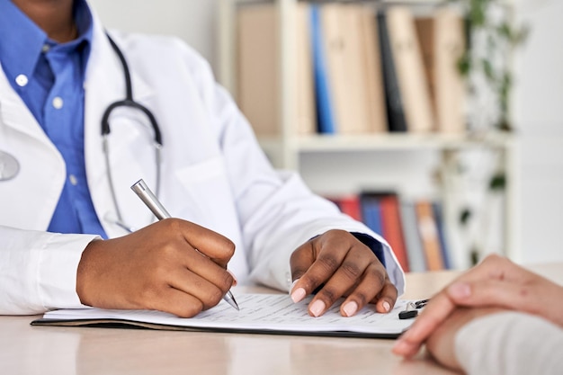 Foto médico negro africano consulta paciente preenchendo formulário médico na consulta