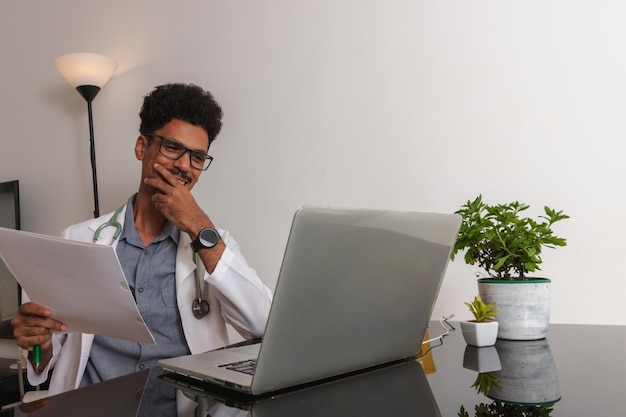 Médico negro brasileño o veterinario trabajando en casa Joven haciendo oficina en casa durante el día en el escritorio con computadora portátil