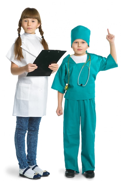 Médico de niña y niño lindo en uniforme de pie