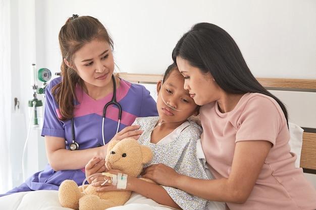 Médico y niño con la madre en el hospital