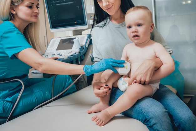 Médico y niño pequeño paciente con su madre