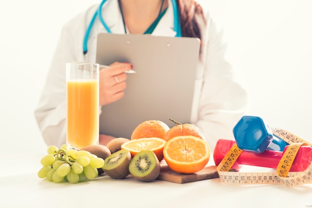 Médico nutricionista em consultório com frutas saudáveis