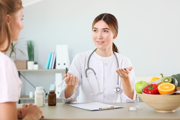 Médico nutricionista lleva a un paciente en la oficina de nutrición adecuada