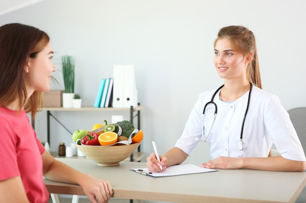 Médico nutricionista lleva a un paciente en la oficina de nutrición adecuada