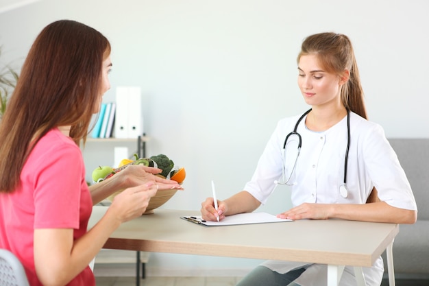 Médico nutricionista lleva a un paciente en la oficina de nutrición adecuada