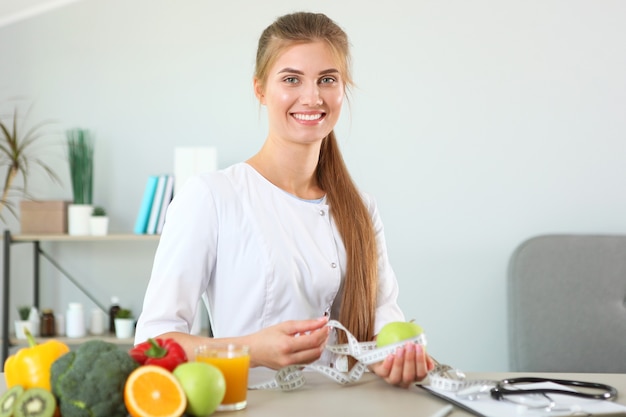 Foto médico nutricionista en su oficina demuestra el concepto de alimentación saludable