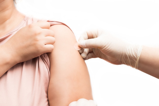 Foto médico o enfermera poniendo una cura al paciente con una mascarilla médica donde lo inyecto.