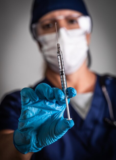 Médico o enfermera sosteniendo una jeringa médica con aguja